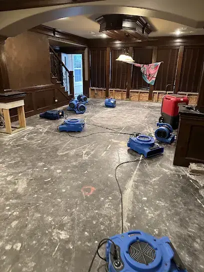 Air movers and a dehumidifier drying a basement rec room in Blue Springs, MO