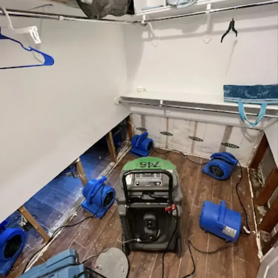 Flood-cut walls with air movers and a dehumidifier drying a room in Blue Springs
