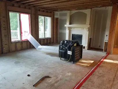 Gutted room with a dehumidifier running and the lower walls removed in Blue Springs