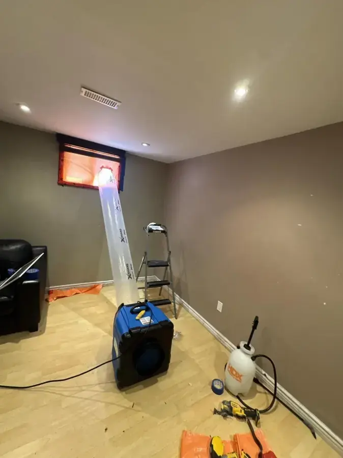 A dehumidifier and an air mover running in an Independence, MO room where the flooring was pulled up after a water loss