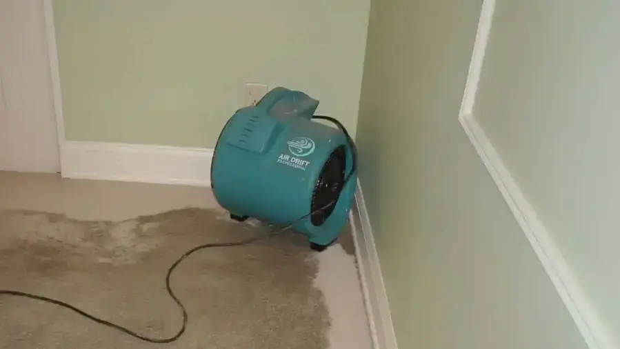 An air mover on the wet floor in the corner of an Independence, MO basement