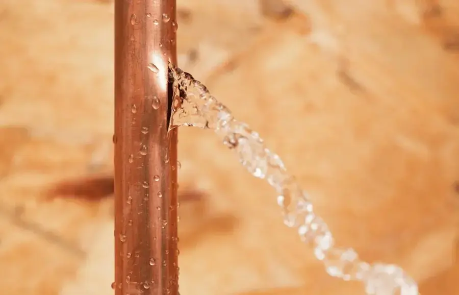 Water spraying from a split copper pipe during a burst pipe loss in Blue Springs